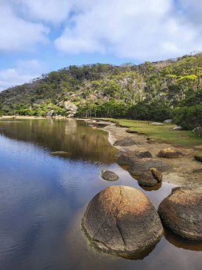 Wilsons Promontory Ulusal Parkı 'ndaki Norman Sahili' ne akan gelgit nehrinin kıyısındaki granit kayalar..