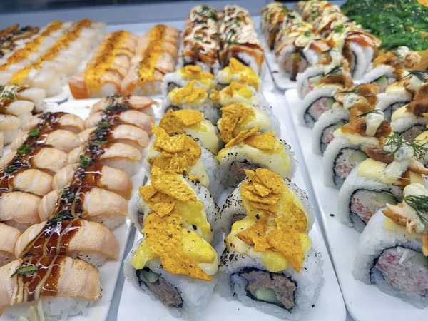 Yemek marketinin vitrininde suşi. Suşi, genellikle biraz şeker ve tuz ile birlikte deniz ürünleri ve sebzeler gibi çeşitli malzemelerle birlikte hazırlanmış bir Japon sirke pilavıdır..