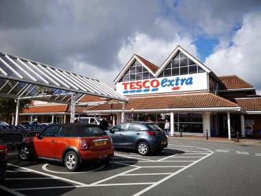 Llanelli, İngiltere: 14 Haziran 2018: Bir Tesco Extra süpermarketinin ana girişi. Engelli park yerleri mağazaya kolay erişim sağlar. Tesco, İngiltere 'nin en büyük süpermarket zinciri..