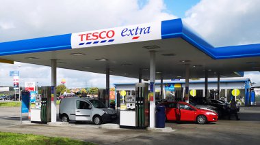 Llanelli, İngiltere: 21 Eylül 2018: Müşteriler araçlarına Tesco Petrol İstasyonu 'nda yakıt ikmali yapıyor. Tesco, İngiliz çok uluslu bir bakkal ve genel ürün perakendecisi.. 