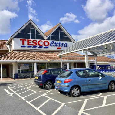 Llanelli, İngiltere: 14 Haziran 2018: Bir Tesco Extra süpermarketinin ana girişi. Engelli park yerleri mağazaya kolay erişim sağlar. Tesco, İngiltere 'nin en büyük süpermarket zinciri..