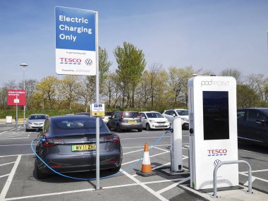 Swansea, İngiltere: 20 Nisan 2021: Pod Point, İngiltere 'nin önde gelen elektrikli araçlar için altyapı şarj etme sağlayıcılarından biridir. Tesla motorlu aracı Tesco otoparkındaki Pod Point şarj istasyonunu kullanıyor..