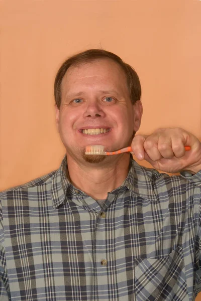 Ένας Άντρας Καρό Πουκάμισο Οδοντόβουρτσα Στο Χέρι Πορτοκαλί Φόντο Βουρτσίζει — Φωτογραφία Αρχείου