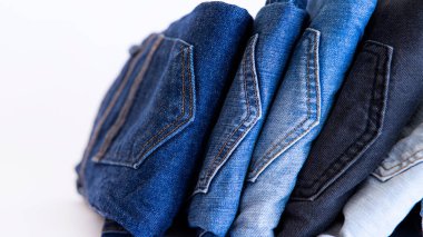 Arka planda kot pantolon, beyaz arka planda mavi ve siyah kot pantolon var.,