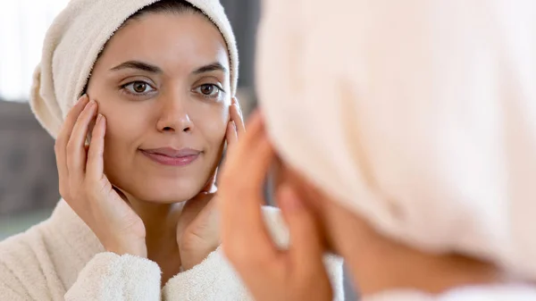 stock image beauty, skin care and people concept - smiling young woman in skin care and looking to mirror at home bathroom