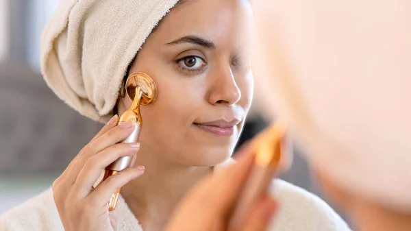 stock image beauty, skin care and people concept - smiling young woman in skin care and looking to mirror at home bathroom