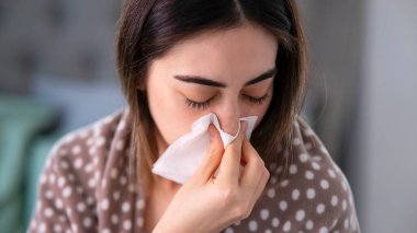 Genç hasta bir kadın yatakta iken onun burun üfleme