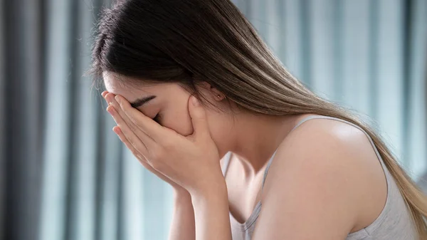 Sad tired young woman touching forehead having headache migraine or depression