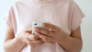 Cep telefonu mesajı atan ya da sohbet eden Asyalı bir kızın eli. Kadın elinin yakınına.