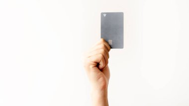 Beyaz arka planda izole edilmiş, kredi kartı, kart veya fiş gösteren bir el..