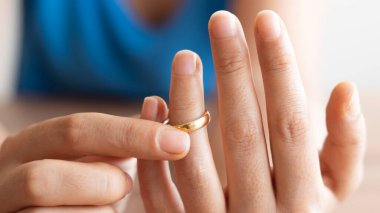 İnsan eli boşanma sözleşmesi imzalıyor, yakın plan. Evlilik sözleşmeli nikah yüzükleri ve arka planda Yargıç Tokmak.