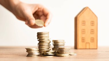 Birisi eve bozuk para, para biriktirme ya da ev ya da gayrimenkul konsepti için yatırım yapma basamaklarıyla para koydu.