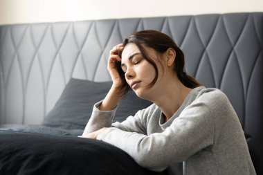 Mutsuz, bunalımlı kadın yatak odasında oturuyor, depresyon konsepti.