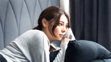 Mutsuz, bunalımlı kadın yatak odasında oturuyor, depresyon konsepti.