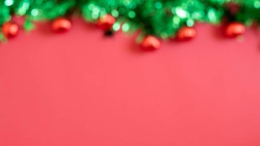 Noel arifesi kavramı. Kurdeleli hediye kutularının en üst görüntüsü yeşil takılar altın yıldız süslemeleri ve izole edilmiş kırmızı arkaplan üzerinde çam dalları ortada kopyalanmış