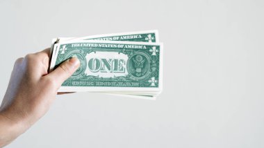 Dolar teklif eden bir kadın, euro banknotları ve bir tomar para tutan bir kadın. Euro, dolar banknotları, Avrupa Birliği kağıt para birimi. Para biriktirme kavramı.
