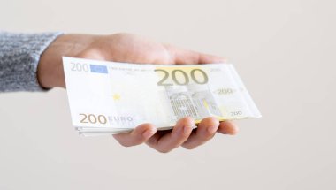 Dolar teklif eden bir kadın, euro banknotları ve bir tomar para tutan bir kadın. Euro, dolar banknotları, Avrupa Birliği kağıt para birimi. Para biriktirme kavramı.