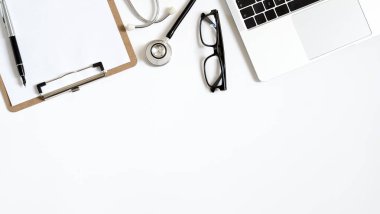 Stetoskop, dizüstü bilgisayar ve metin için kopya alanı olan doktor ofis çalışmalarının üst görünümü.