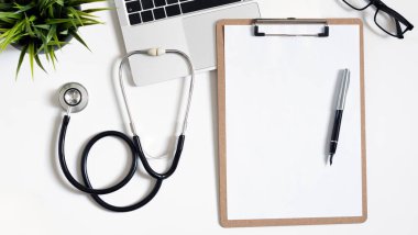 Stetoskop, dizüstü bilgisayar ve metin için kopya alanı olan doktor ofis çalışmalarının üst görünümü.