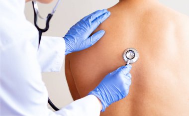 Doktor, bir tıp merkezindeki muayene sırasında olgun hastasının kalbini kontrol ediyor.