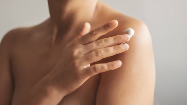 Koluna vücut kremi süren bir kadın, güzellik derisi konsepti.