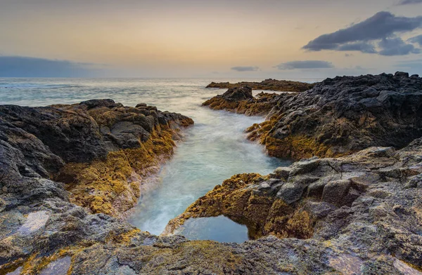 Dalgalar İspanya 'nın Kanarya Adaları, Tenerife' nin kuzey kıyısında bir su birikintisinde kırılıyor..