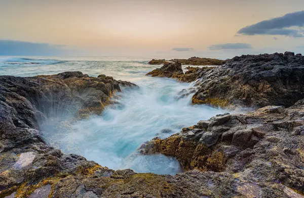 Dalgalar İspanya 'nın Kanarya Adaları, Tenerife' nin kuzey kıyısında bir su birikintisinde kırılıyor..