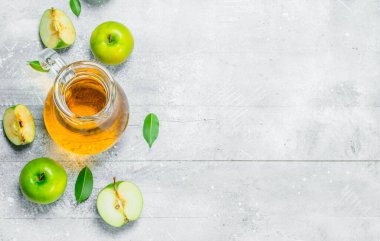 Suyu ve bir bardak taze elma elma dilimleri ile jar. Beyaz rustik arka plan üzerinde.