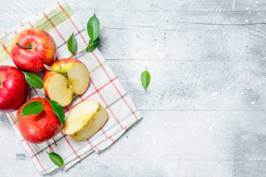 Peçetedeki kırmızı elmalar. Beyaz rustik arka plan üzerinde.