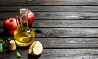Taze elma ile elma sirkesi. Ahşap arka plan üzerinde.