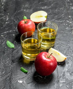 Bir kutu içinde taze elma ile elma suyu cam kavanozda. Karanlık bir rustik arka plan üzerinde.