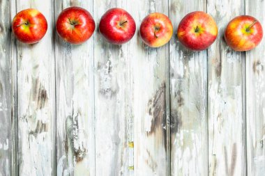 Kırmızı sulu elmalar. Beyaz ahşap arka planda.