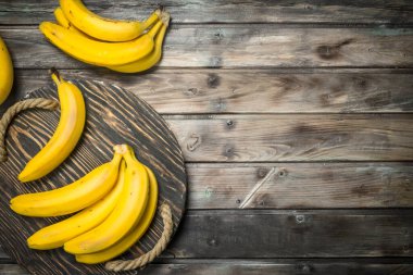 Taze muz bir siyah eski ahşap tepsi. Koyu ahşap arka plan üzerinde.