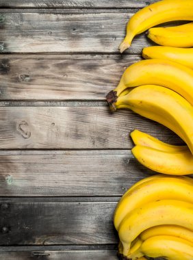 Bir sürü taze aromatik muz. Siyah bir ahşap arka plan üzerinde.