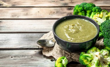 Bir kasede brokoli bir kaşık ile püre. Ahşap bir arka plan üzerinde.