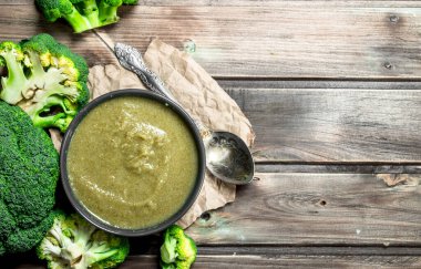 Bir kasede brokoli bir kaşık ile püre. Ahşap bir arka plan üzerinde.