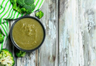 Bir kasede püresi olgunlaşmış brokoli. Ahşap bir arka plan üzerinde.