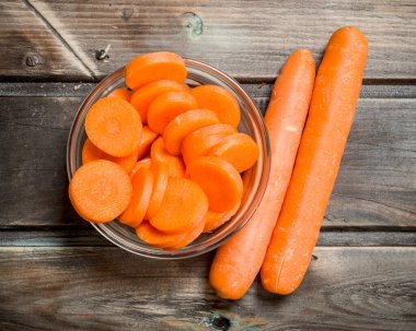 Bir cam kapta havuç parçalarını. Ahşap arka plan üzerinde