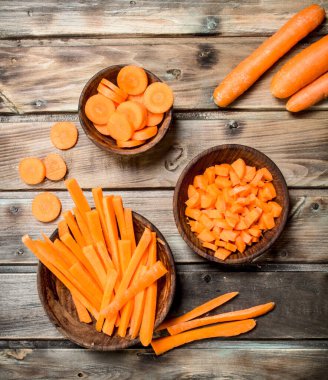 Bir kase üzerinde taze havuç parçalarını. Ahşap arka plan üzerinde