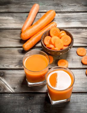 Havuç suyu ve bir kase içinde havuç parçalarını. Ahşap arka plan üzerinde