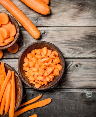 Bir kase üzerinde taze havuç parçalarını. Ahşap arka plan üzerinde