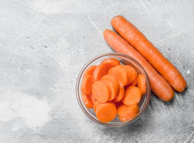 Bir cam kapta havuç parçalarını. Rustik arka plan üzerinde