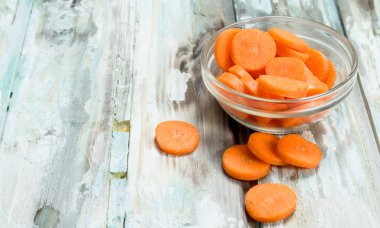 Bir cam kapta havuç parçalarını. Ahşap arka plan üzerinde