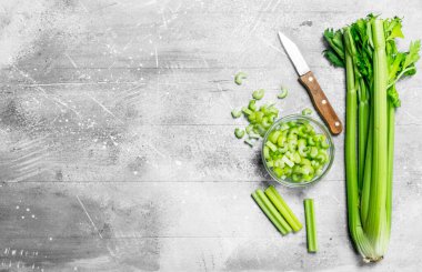 Kereviz bir bıçak ile bir kase dilimlenmiş. Rustik arka plan üzerinde