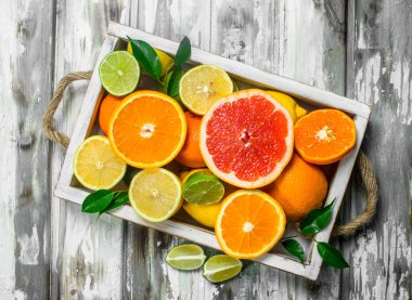 Taze narenciye içinde tepsi. Ahşap arka plan üzerinde