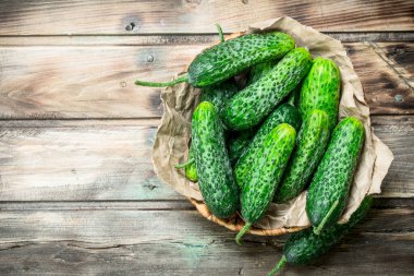 Yeşil salatalık sepet. Ahşap arka plan üzerinde