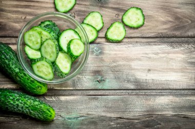 Salatalık ve salatalık dilimleri bir cam kabın içinde. Ahşap arka plan üzerinde