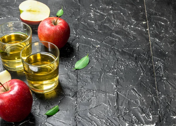 stock image Apple juice in a glass jar with fresh apples in a box. On a dark rustic background.