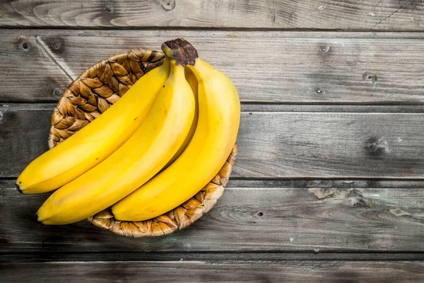 stock image Bunch of bananas in the basket. On a black wooden background.