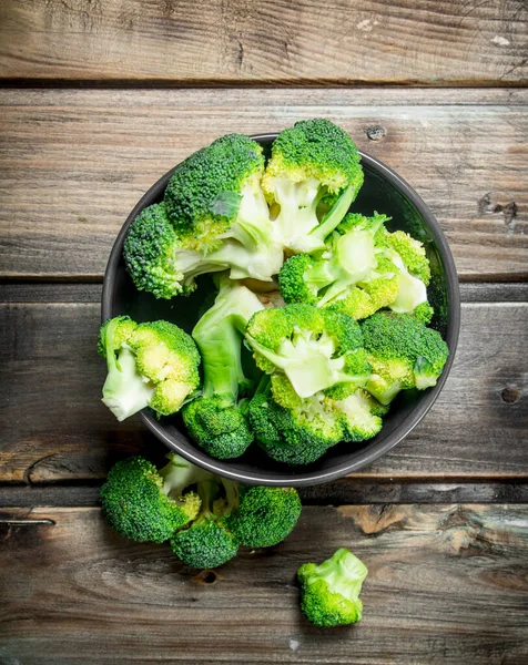 stock image broccoli in a bowl. On a wooden background.